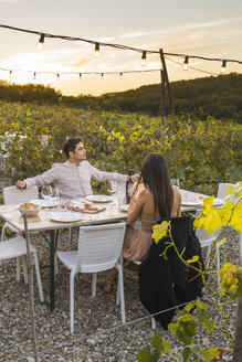 Italien, Toskana, Siena, junges Paar beim Abendessen in einem Weinberg - FBAF00188