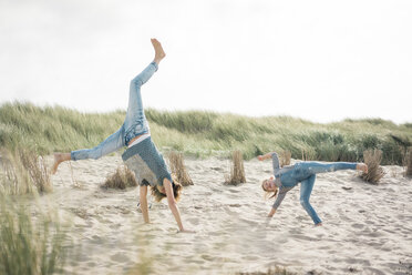 Mutter und Tochter amüsieren sich am Strand und drehen sich im Kreis - MOEF01585