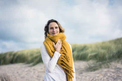 Mature woman relaxing in the dunes, enjoying the wind - MOEF01587