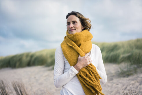 Mature woman relaxing in the dunes, enjoying the wind - MOEF01588