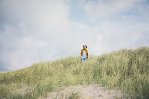 Mature woman relaxing in the dunes, enjoying the wind - MOEF01594