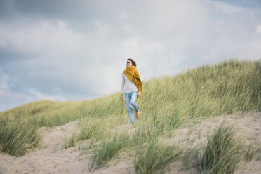 Ältere Frau entspannt sich in den Dünen und genießt den Wind - MOEF01595