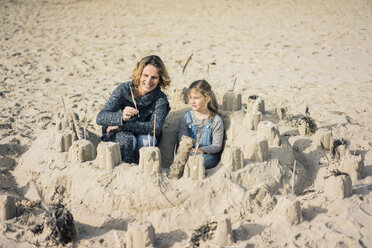 Mutter und Tochter bauen eine Sandburg am Strand - MOEF01623