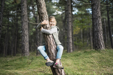 Mädchen, das einen Baum im Wald umarmt - MOEF01647