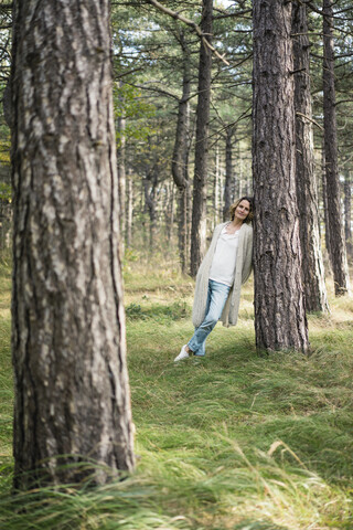 Gelassene Frau im Wald stehend, lizenzfreies Stockfoto