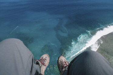 Low section of man sitting over sea - CAVF56122