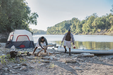 Männliche Freunde genießen auf dem Campingplatz am See - CAVF56281