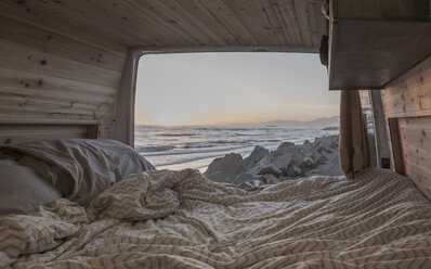 Laken und Kissen im Wohnmobil gegen Meer und Himmel bei Sonnenuntergang - CAVF56364