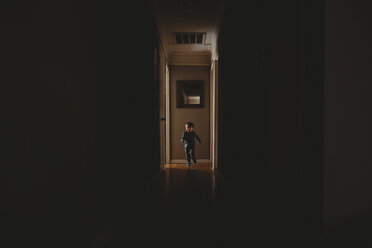Full length of boy running in corridor at home - CAVF56369