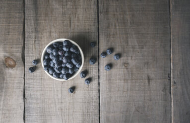 Overhead view of blueberries in bowl on wooden table - CAVF56373