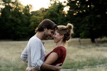 Happy couple in nature, standing face to face, caressing each other - HHLMF00585