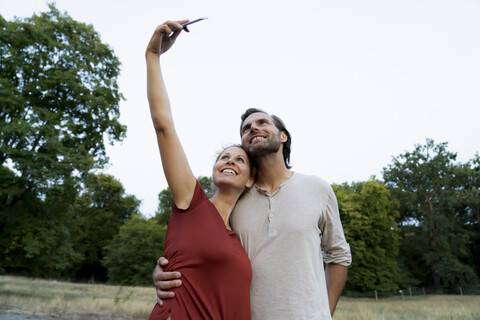 Glückliches Paar macht Selfies im Freien, lizenzfreies Stockfoto