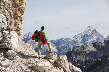 Italien, Cortina d'Ampezzo, Mann mit Seil und Kletterausrüstung mit Blick auf die Aussicht - WPEF01133