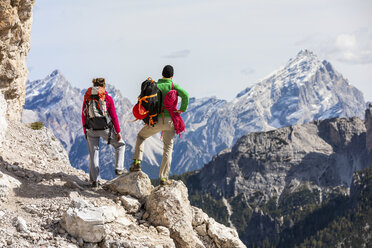 Italien, Cortina d'Ampezzo, Paar mit Seil und Kletterausrüstung mit Blick auf die Aussicht - WPEF01135