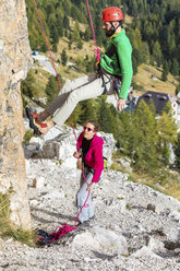 Italien, Cortina d'Ampezzo, Mann beim Abseilen in den Dolomiten mit Hilfe einer Frau - WPEF01152