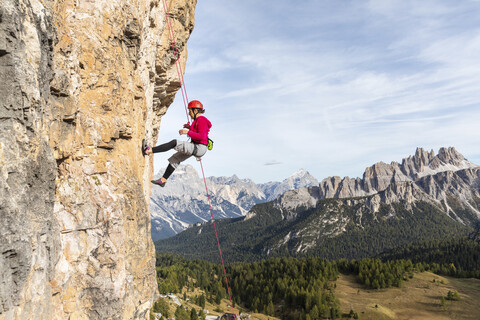 Italien, Cortina d'Ampezzo, Frau beim Abseilen in den Dolomiten, lizenzfreies Stockfoto