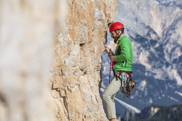 Italien, Cortina d'Ampezzo, Mann sichert das Seil beim Klettern in den Dolomiten - WPEF01170