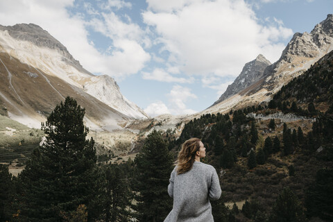 Schweiz, Graubünden, Albulapass, Frau in Berglandschaft stehend, lizenzfreies Stockfoto