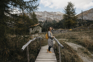 Schweiz, Engadin, Frau auf Wanderschaft auf einer Holzbrücke - LHPF00156