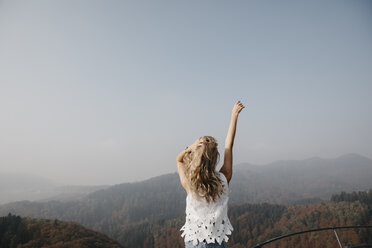 Germany, Black Forest, Sitzenkirch, young woman enjoying the view of mountain forest - LHPF00164