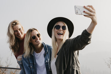 Drei glückliche junge Frauen machen ein Selfie im Freien - LHPF00168