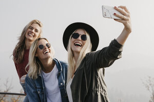 Drei glückliche junge Frauen machen ein Selfie im Freien - LHPF00169