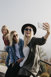 Germany, Black Forest, Sitzenkirch, three happy young women taking a selfie at Sausenburg Castle - LHPF00170