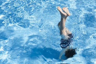 Low section of girl wearing striped underwear while diving into swimming  pool stock photo