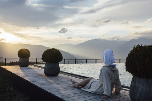 Woman relaxing at the poolside, wearing bathrobe and turban - LHPF00173