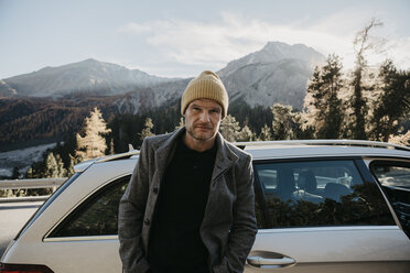 Mann auf Reisen durch die Schweiz, neben seinem Auto stehend - LHPF00179