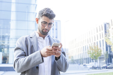 Portrait of young businessman using cell phone - TCF05984