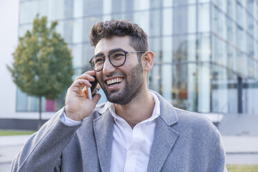 Portrait of laughing young businessman on the phone - TCF05985