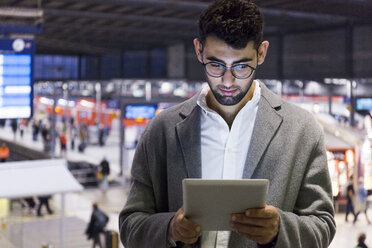 Deutschland, München, junger Geschäftsmann mit digitalem Tablet am Hauptbahnhof - TCF06001