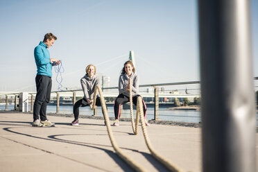 Freunde beim Training am Flussufer, Seilziehen - MOEF01669