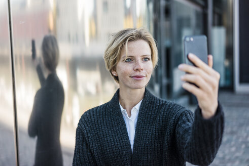 Junge Geschäftsfrau macht Selfie mit ihrem Smartphone - MOEF01695