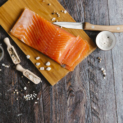 Nahaufnahme von Lachs mit Gewürzen auf einem Schneidebrett am Tisch - CAVF56444