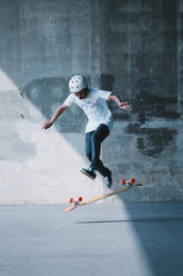 Carefree man skateboarding on road - CAVF56457