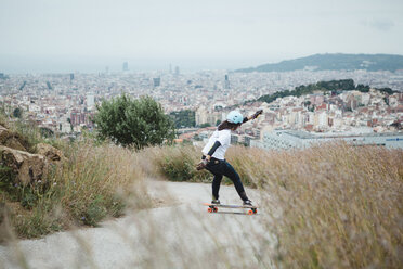 Side view of woman skateboarding on road against sky - CAVF56461