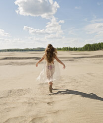 Rückansicht einer jungen Frau im Bikini, die am Strand gegen den Himmel läuft - CAVF56474