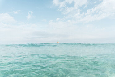 Mid distance view of man swimming in sea against sky - CAVF56573