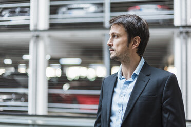 Portrait of a businessman, standing in parking garage - DIGF05514