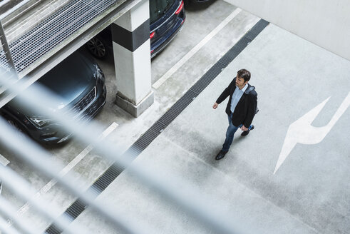 Businessman walking in parking garage - DIGF05523