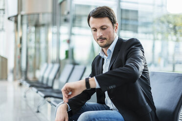 Businessman sitting at the airport, waiting - DIGF05542