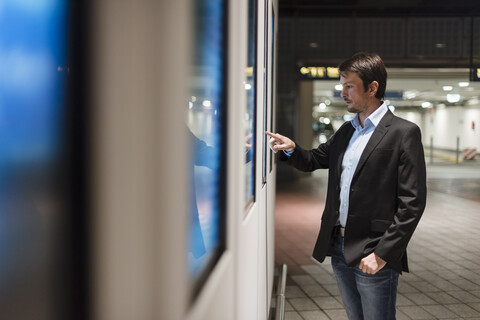 Geschäftsmann vor einer Informationstafel in der Stadt, lizenzfreies Stockfoto