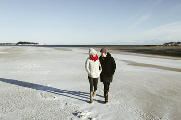 In voller Länge der weiblichen Freunde zu Fuß auf verschneiten Feld gegen den Himmel im Winter - CAVF56725