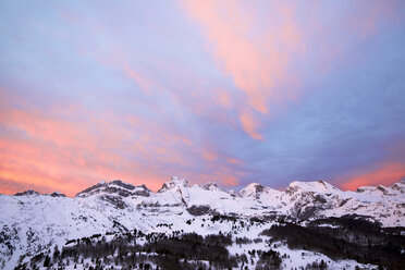 Low angle scenic view of snowcapped mountains against dramatic sky during sunset - CAVF56726