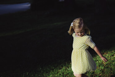 High angle view of girl standing on grassy field at park - CAVF56728