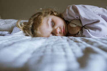 Cute girl with toy sleeping on bed at home - CAVF56749