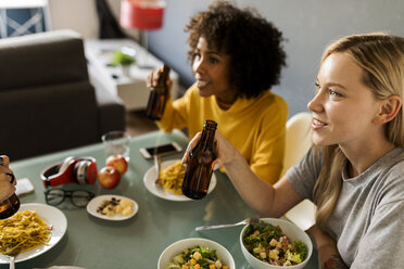 Freundinnen sitzen am Tisch, essen und trinken Bier - VABF01866