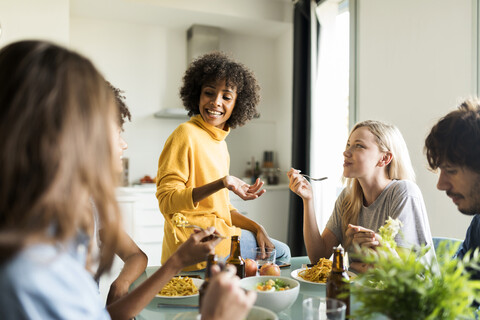 Friends sitting at table talking, eating and drinking beer stock photo